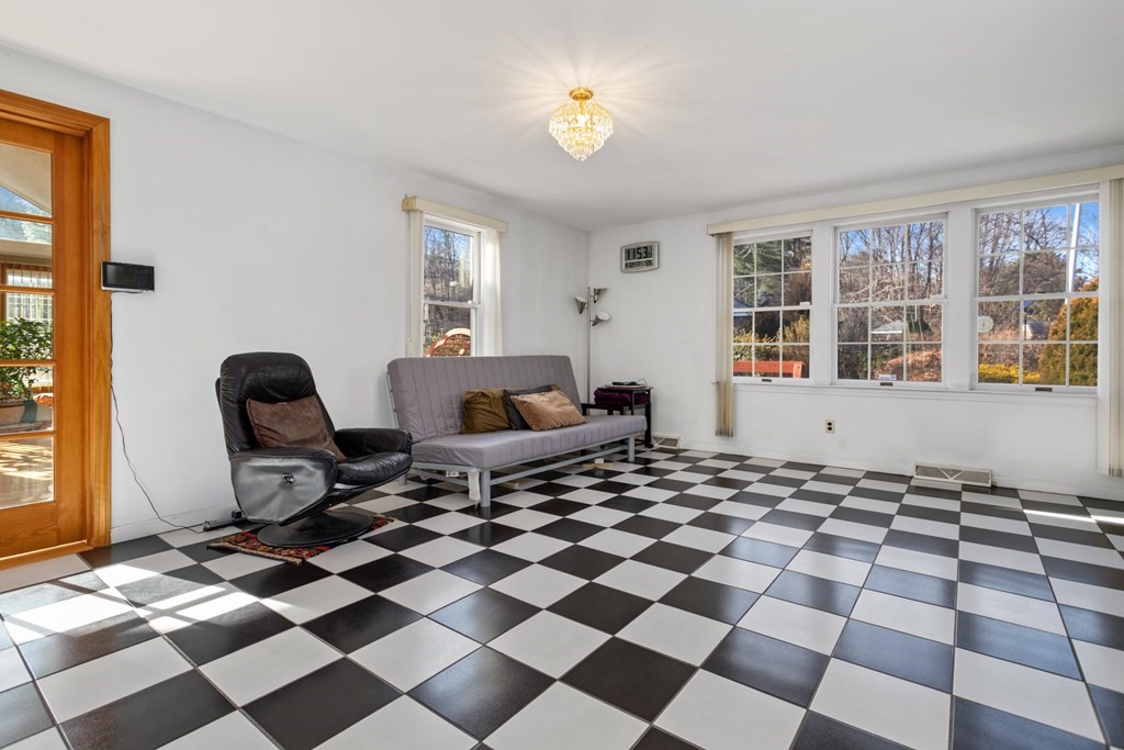 1 Hammersmith Drive Saugus, MA 01906 - Photo 32 of 39 a living room with a black white checkered floor with a gaming machine and dining chairs