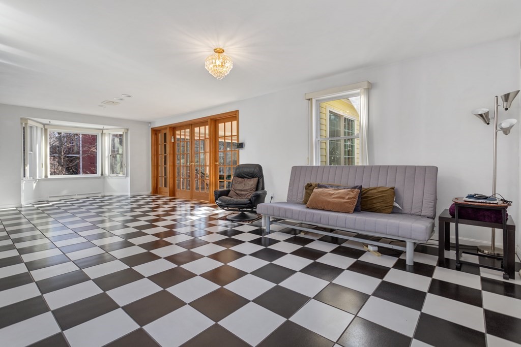 1 Hammersmith Drive Saugus, MA 01906 - Photo 34 of 39 a living room with a black white checkered floor with a gaming machine and dining chairs