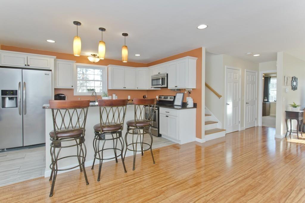 445 Monson Road Wilbraham, MA 01095 - Photo 12 of 42 a kitchen with stainless steel appliances a dining table chairs and wooden floor