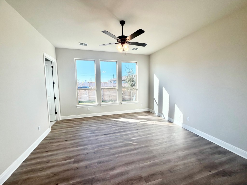 500 Bloomington Loop Hutto, TX 78634 - Photo 11 of 18 a view of an empty room with window and wooden floor