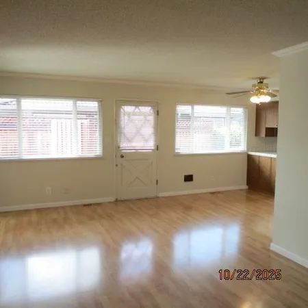 a view of a room with wooden floor and a window