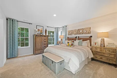 a spacious bedroom with a bed a table and large window