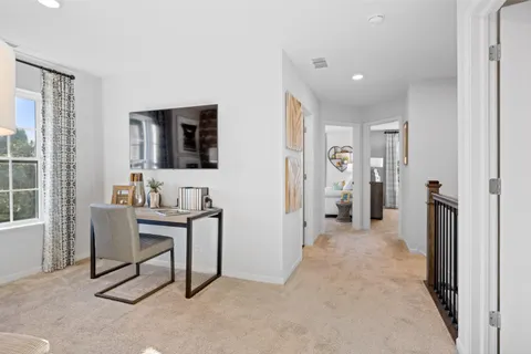 a view of a workspace with furniture and a window
