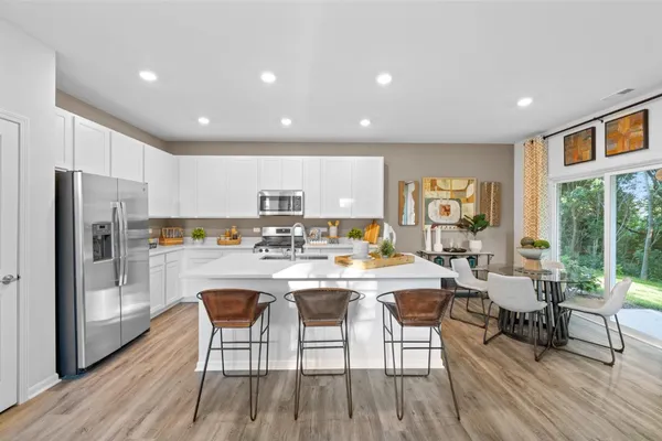 a kitchen with a dining table chairs refrigerator refrigerator and cabinets