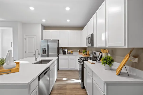 a kitchen with a sink dishwasher a stove and a refrigerator with wooden floor