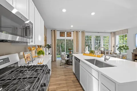 a kitchen that has a lot of cabinets in it and wooden floors