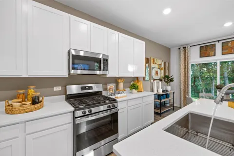 a kitchen with a stove a sink and a microwave