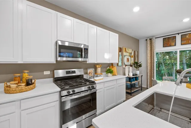 a kitchen with a stove a sink and a microwave