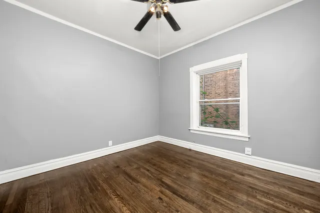 an empty room with a window and a ceiling fan