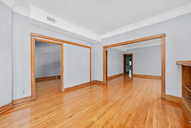 a view of an empty room with wooden floor