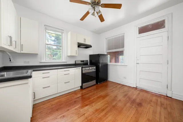 a kitchen with a refrigerator stove and white cabinets