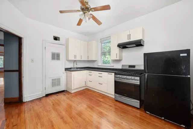a kitchen with stainless steel appliances a stove a refrigerator and white cabinets
