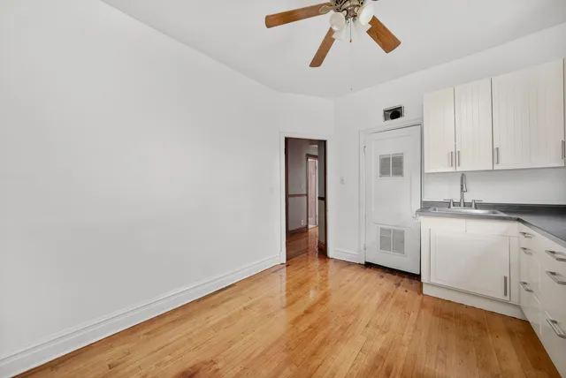 a view of a kitchen with a sink and dishwasher with wooden floor