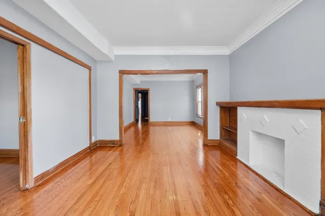 a view of empty room with wooden floor and fireplace