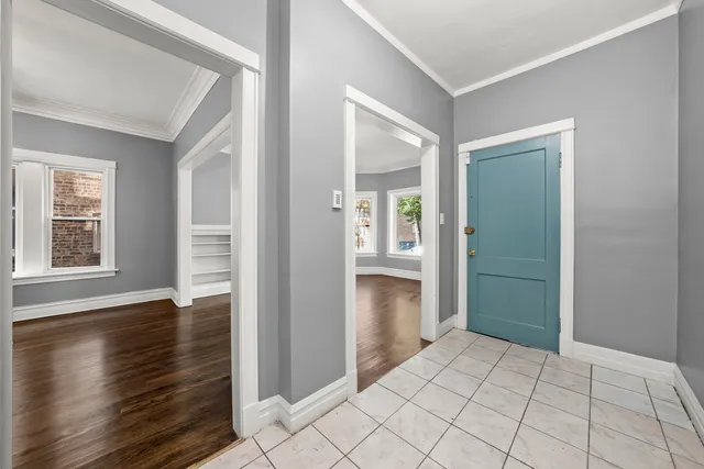 an empty room with wooden floor cabinet and windows