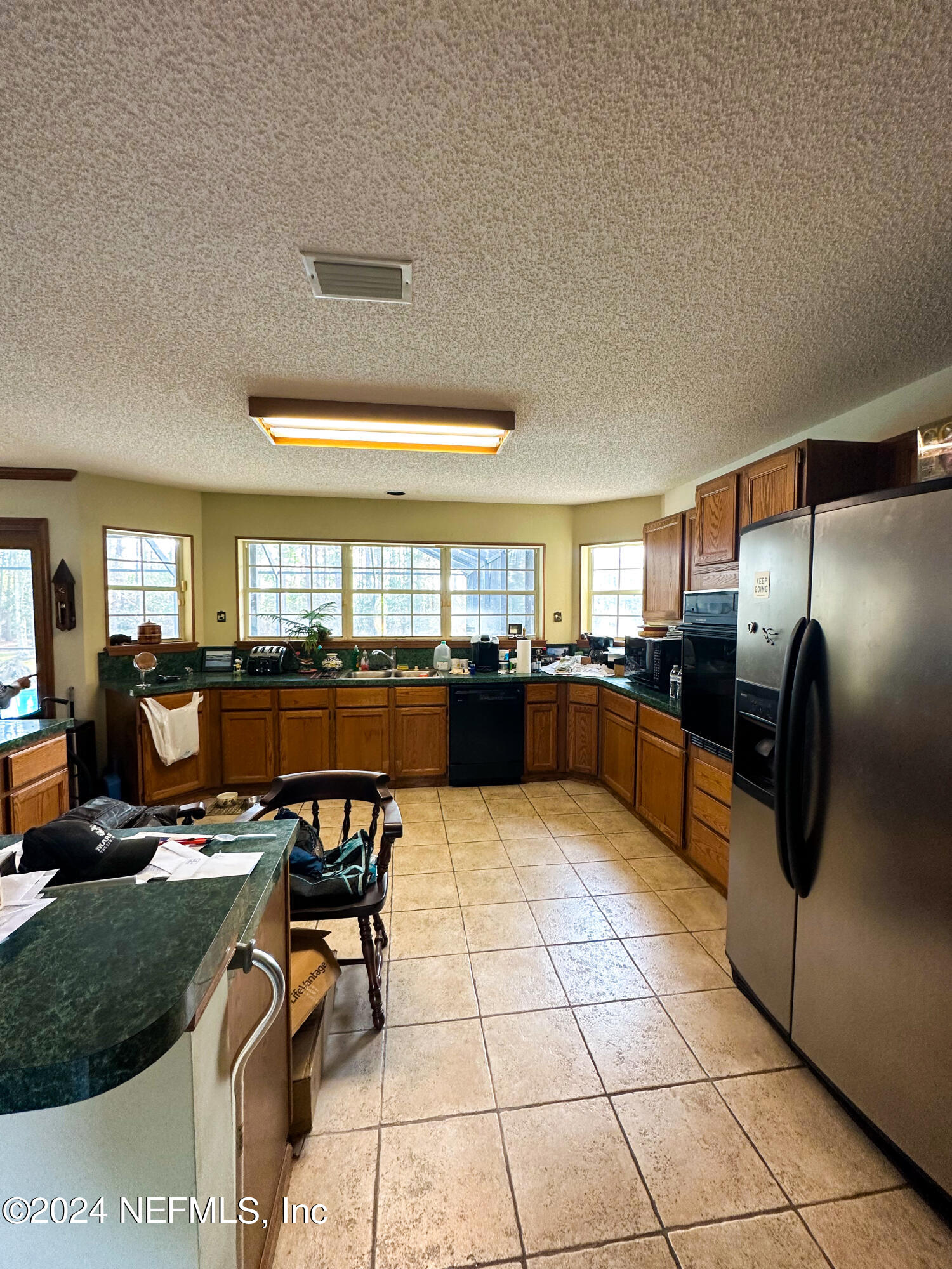 10601 Quail Ridge Drive Ponte Vedra, FL 32081 - Photo 15 of 17 a kitchen with stainless steel appliances kitchen island granite countertop a refrigerator and a view living room