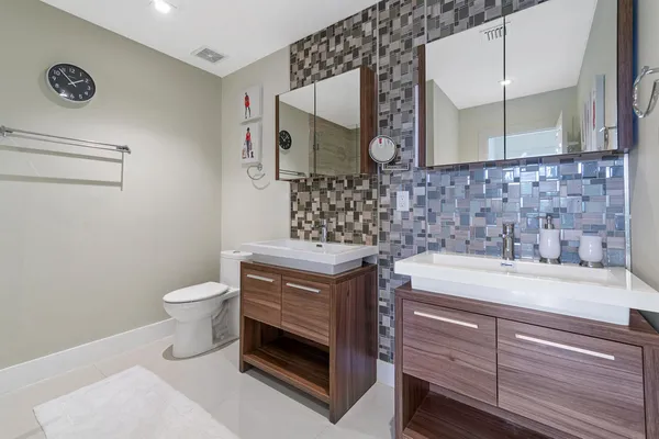 a bathroom with a sink a toilet and mirror
