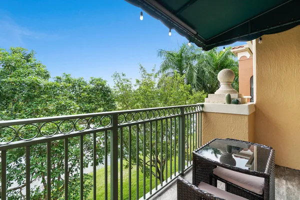 a balcony with wooden floor table and chairs