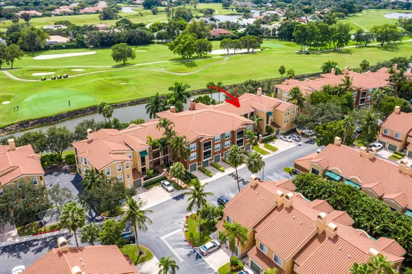 an aerial view of a house with a garden and lake view
