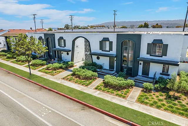 a front view of a house with a garden and plants