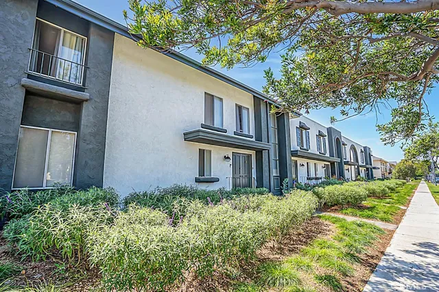 a view of a house with a yard and potted plants