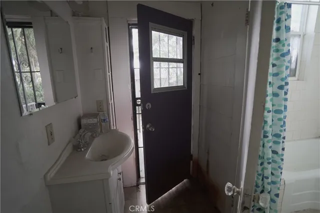 a view of a livingroom with furniture staircase ceiling fan and window