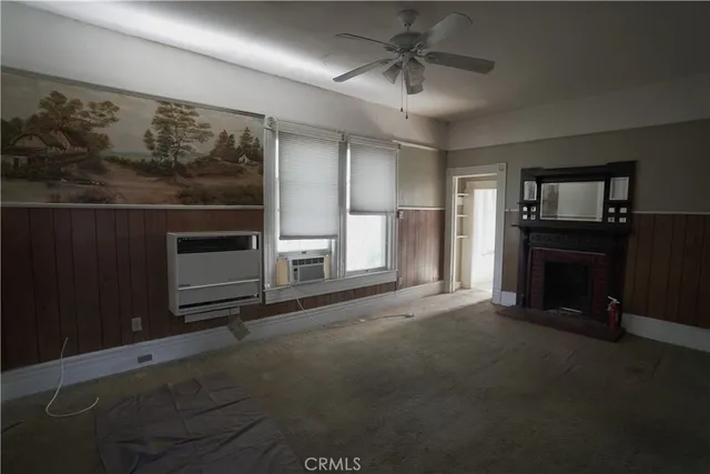 an empty room with windows and fireplace