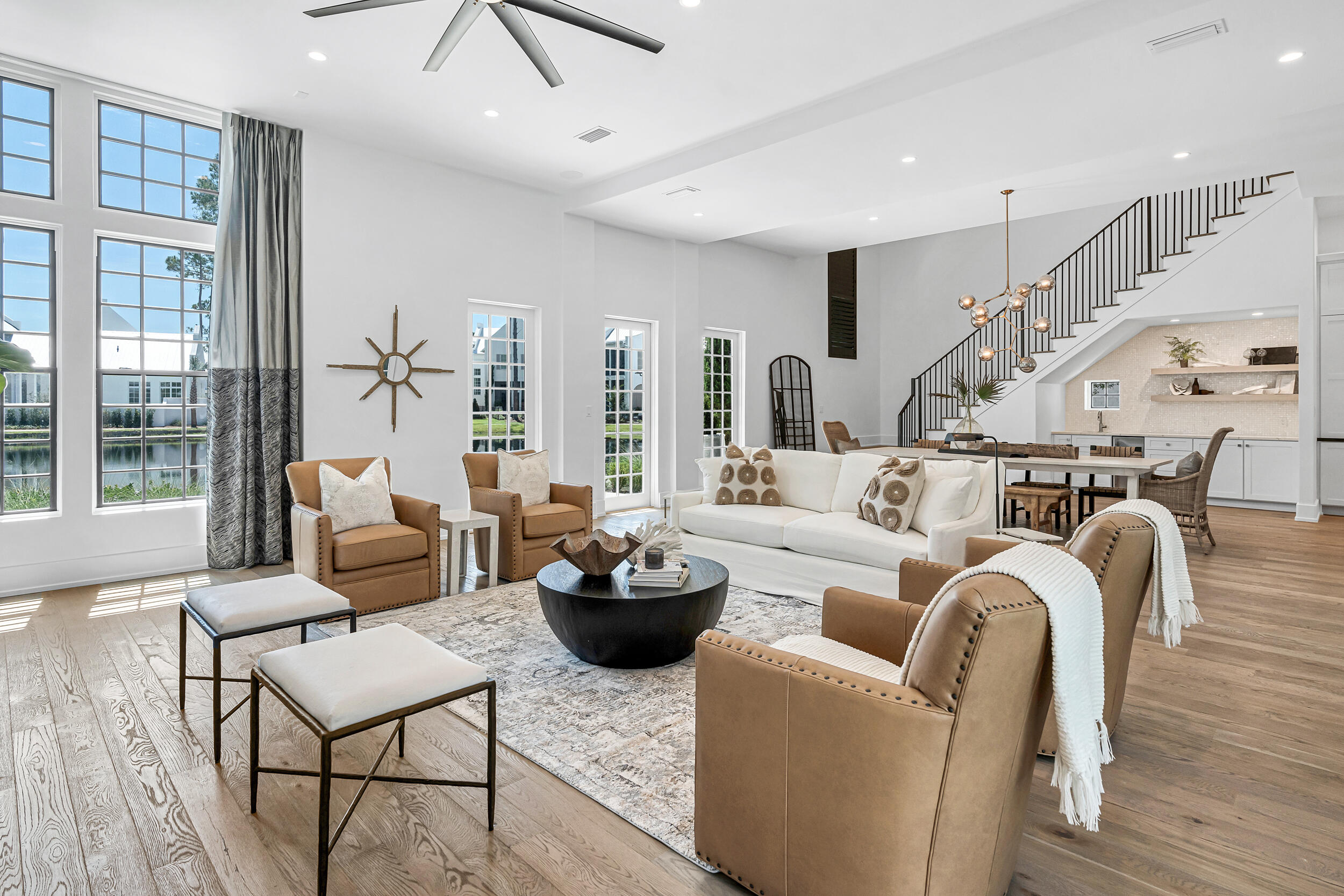 a living room with furniture kitchen view and a large window