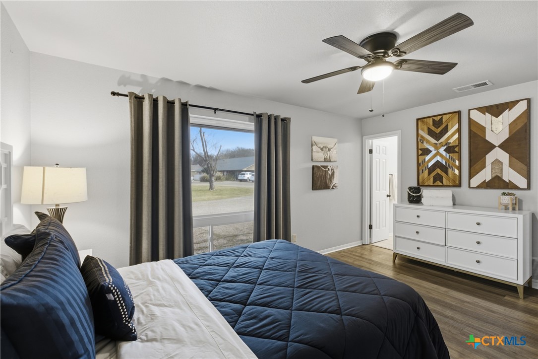 1710 Old Mill Road, Unit 12 Salado, TX 76571 - Photo 31 of 42 a bedroom with a large bed and a chandelier
