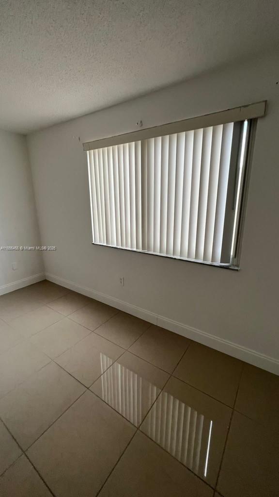 6950 Miami Gardens Drive, Unit 2508 Hialeah, FL 33015 - Photo 18 of 27 a view of an empty room and window