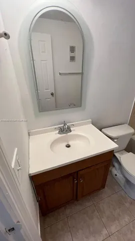 a bathroom with a sink a toilet a mirror and shower