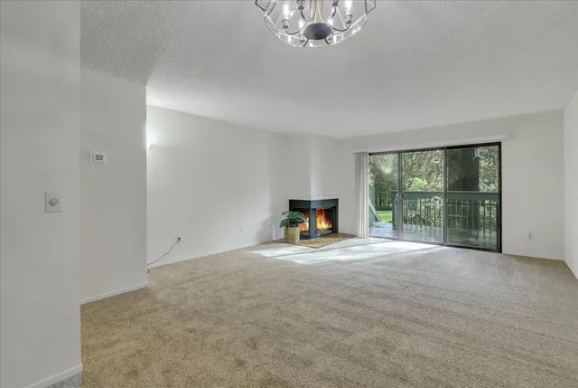 a view of an empty room with a fireplace and a window