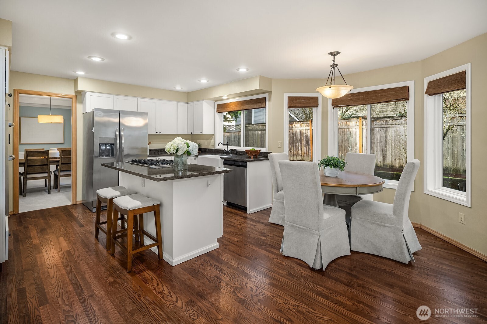 4662 244th Place Southeast Issaquah, WA 98029 - Photo 12 of 40 a dining hall with stainless steel appliances granite countertop wooden floor a dining table and chairs