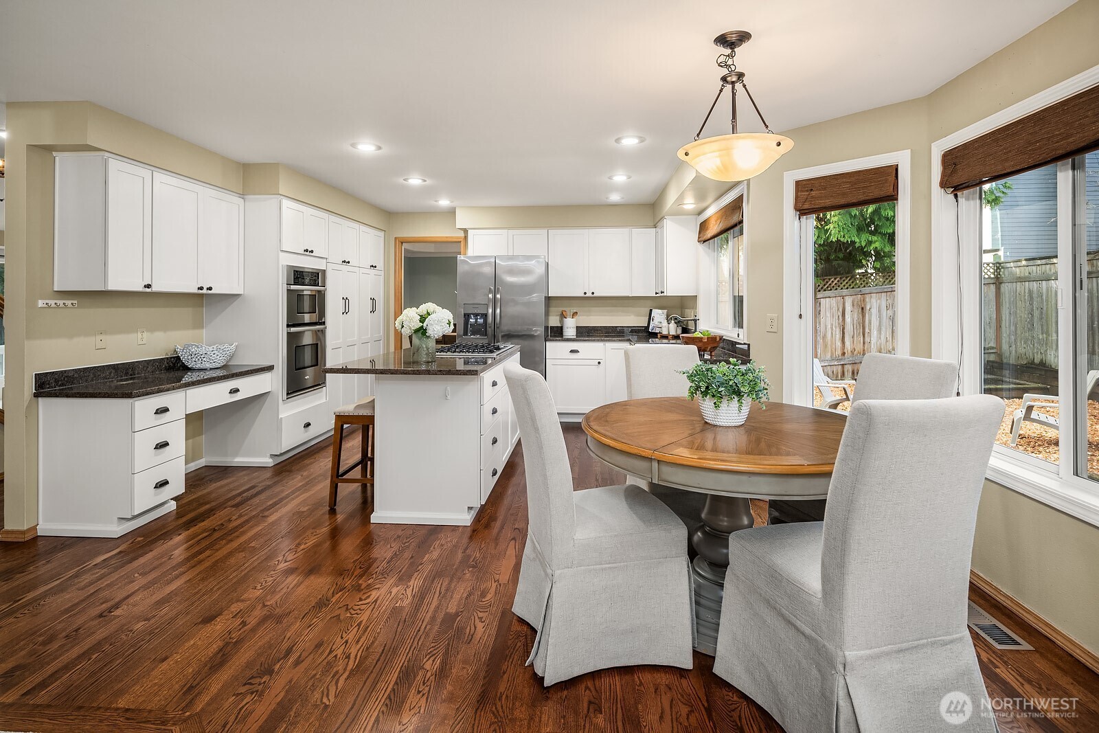4662 244th Place Southeast Issaquah, WA 98029 - Photo 13 of 40 a kitchen with a table chairs refrigerator and cabinets