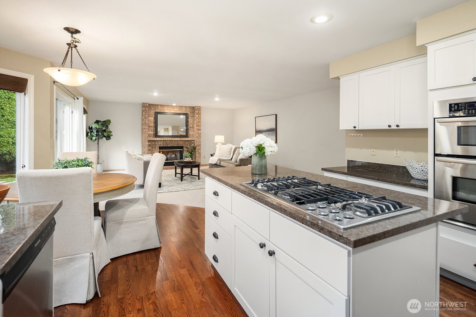4662 244th Place Southeast Issaquah, WA 98029 - Photo 15 of 40 a kitchen with stainless steel appliances granite countertop a stove top oven a sink dishwasher and white cabinets with wooden floor