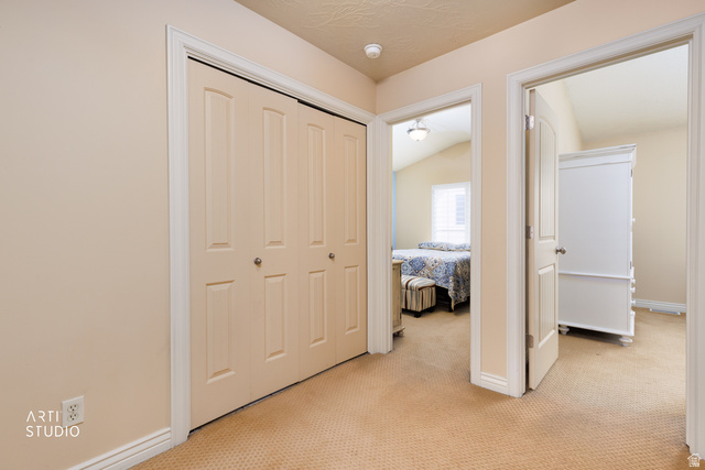 6761 950 East Midvale, UT 84047 - Photo 17 of 44 Hallway featuring neutral-toned walls, textured ceiling, and patterned carpeting