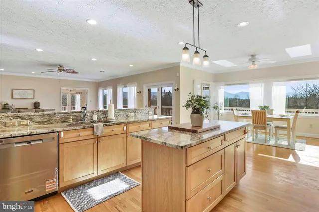 a kitchen with stainless steel appliances granite countertop a stove a sink and a granite counter tops with white cabinets
