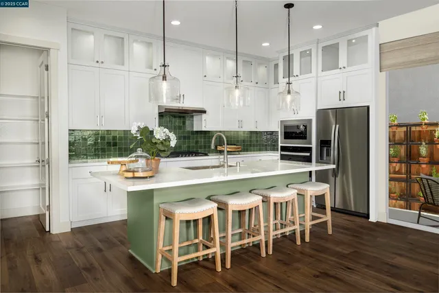 a kitchen with stainless steel appliances granite countertop a table chairs stove and wooden floor