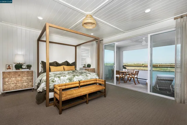 a bedroom with furniture and a floor to ceiling window