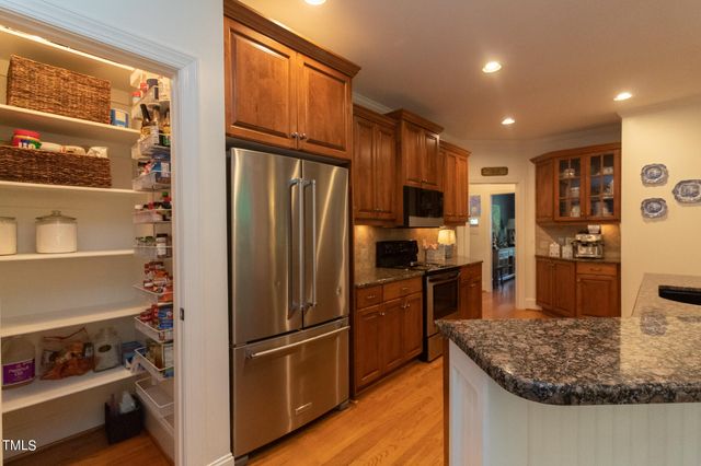 a kitchen with stainless steel appliances granite countertop a stove a sink dishwasher and a refrigerator