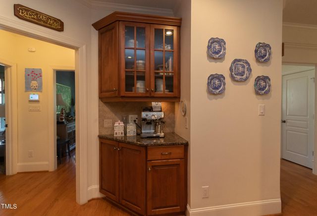 a kitchen with stainless steel appliances granite countertop a sink a stove a dining table and chairs