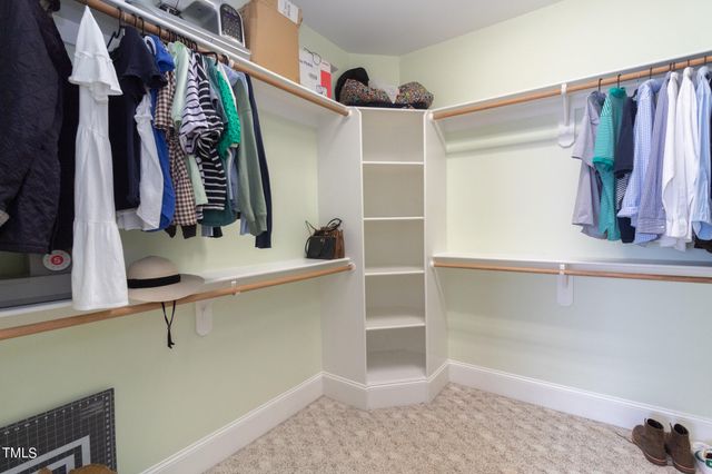 a view of walk in closet with clothes and shoes