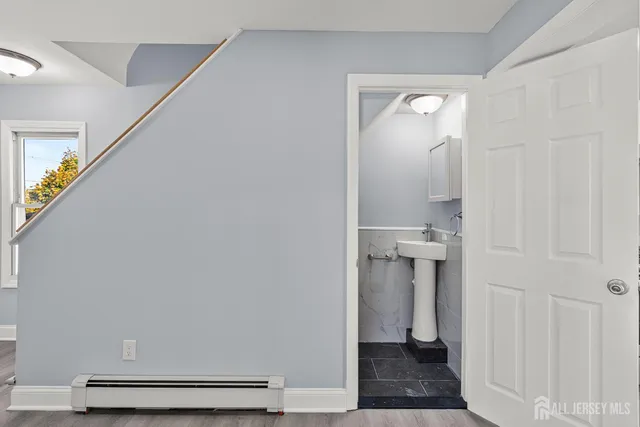 a view of a hallway with white walls and stairs
