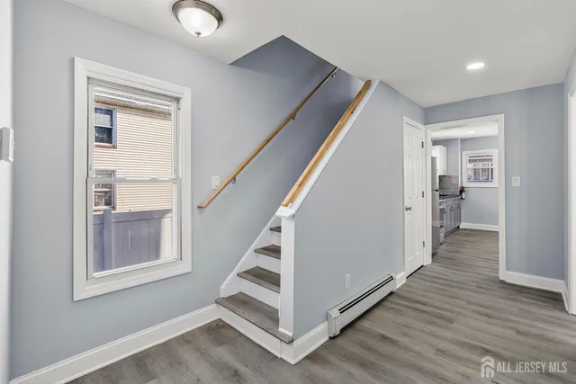 a view of a hallway with wooden floor and entryway
