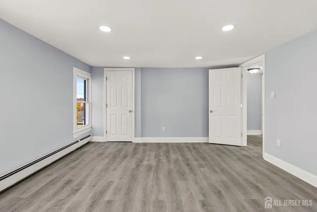 a view of an empty room with wooden floor