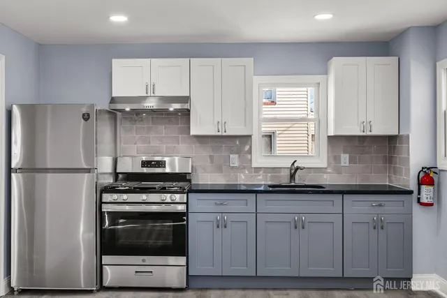 a kitchen with cabinets appliances a sink and a window