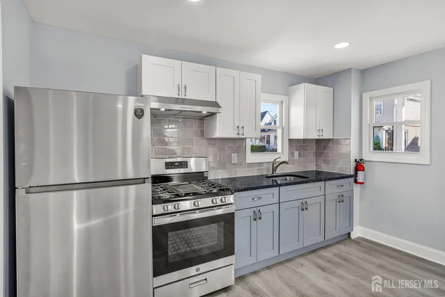 a kitchen with stainless steel appliances granite countertop a refrigerator sink and stove