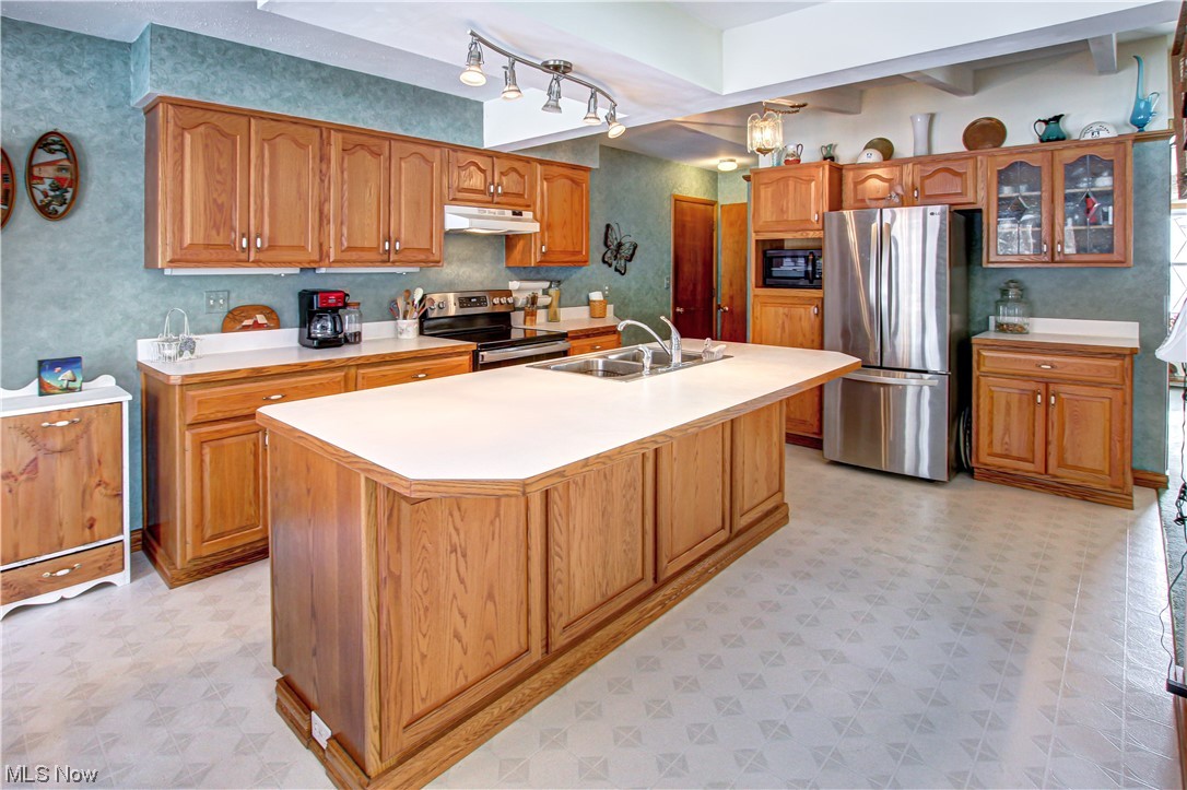 3711 Ruth Drive Brunswick, OH 44212 - Photo 2 of 35 Kitchen featuring a kitchen island with sink, light tile flooring, sink, and appliances with stainless steel finishes
