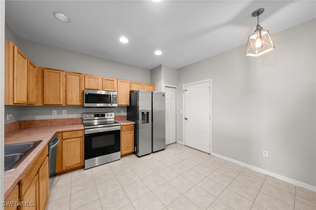 3844 Cherrybrook Loop Fort Myers, FL 33966 - Photo 4 of 29 a kitchen with stainless steel appliances granite countertop a stove a refrigerator and a sink with granite countertops