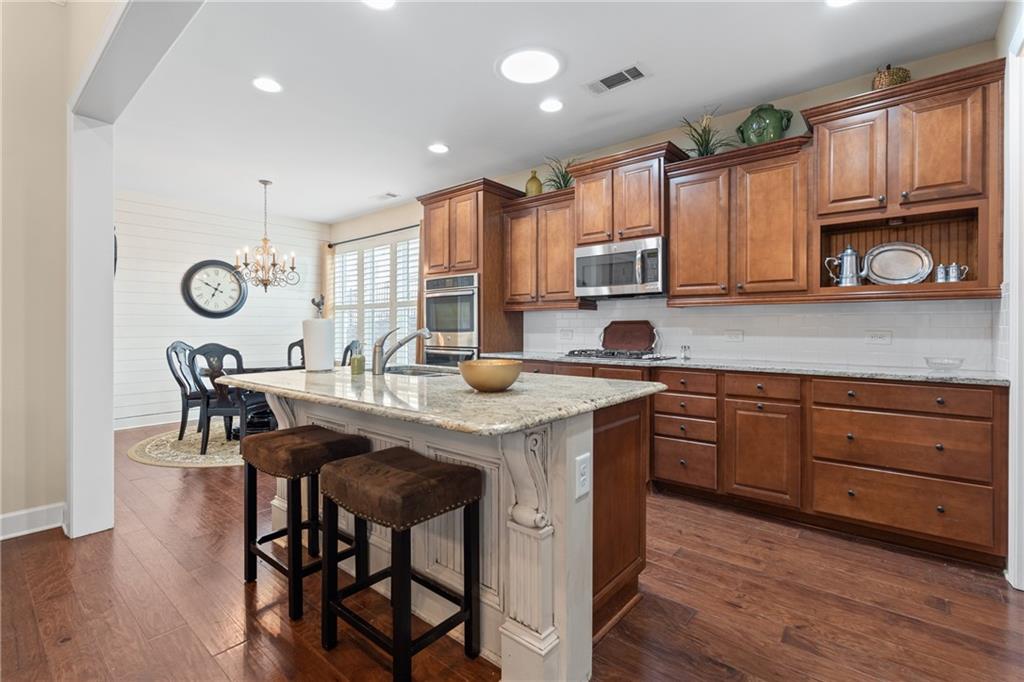 3457 Locust Cove Road Gainesville, GA 30504 - Photo 12 of 54 a kitchen with stainless steel appliances granite countertop wooden cabinets a stove a sink and a refrigerator